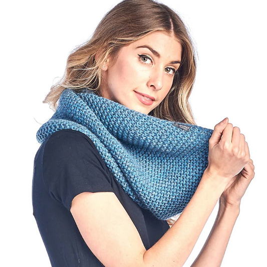 Woman wearing a blue knitted scarf on a white background